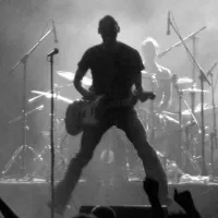 man performing on stage with guitar